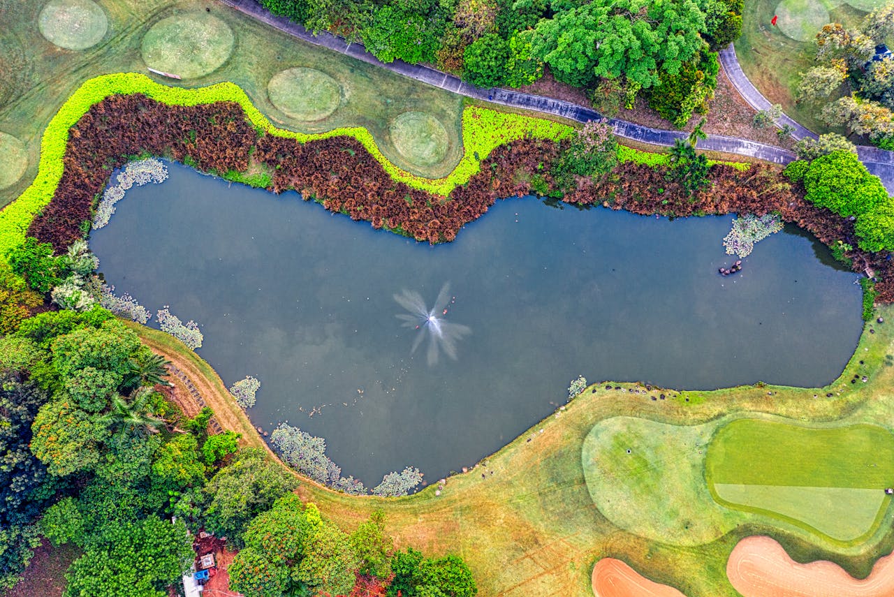 services-04 Stunning aerial view of a golf course with vibrant greenery and a pond in Banten, Indonesia.